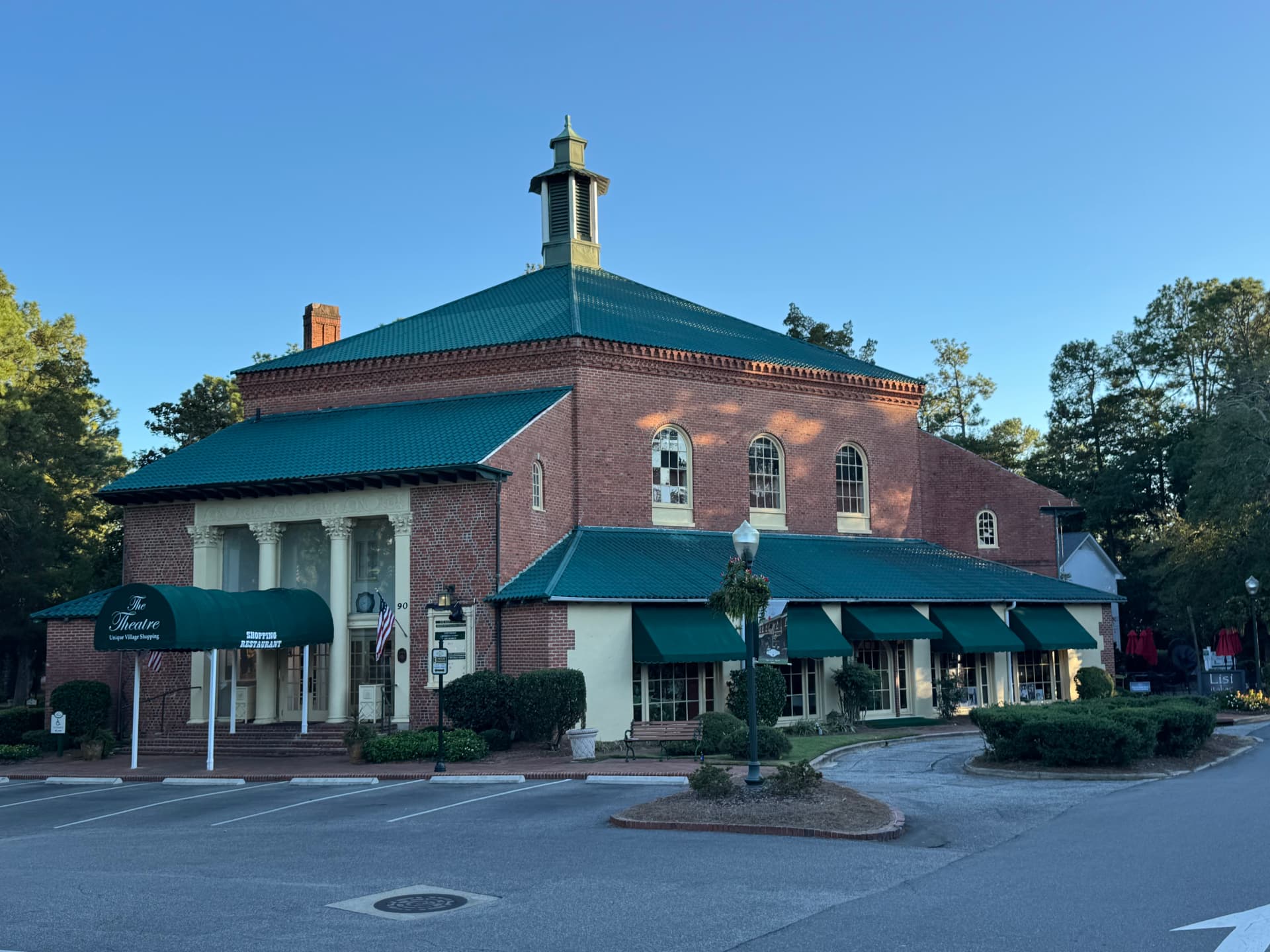 Historic brick theatre building with green awnings in the Village of Pinehurst