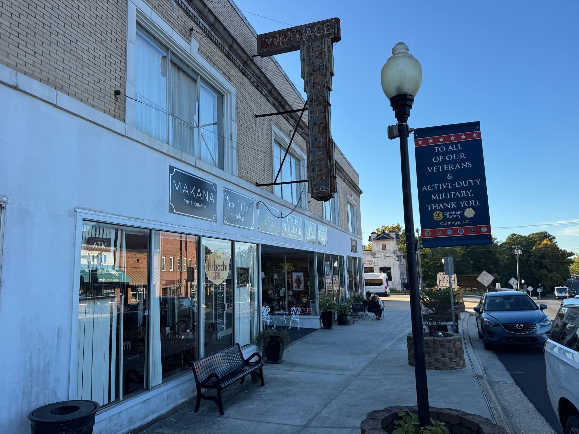 Local storefronts and sidewalk in downtown Carthage