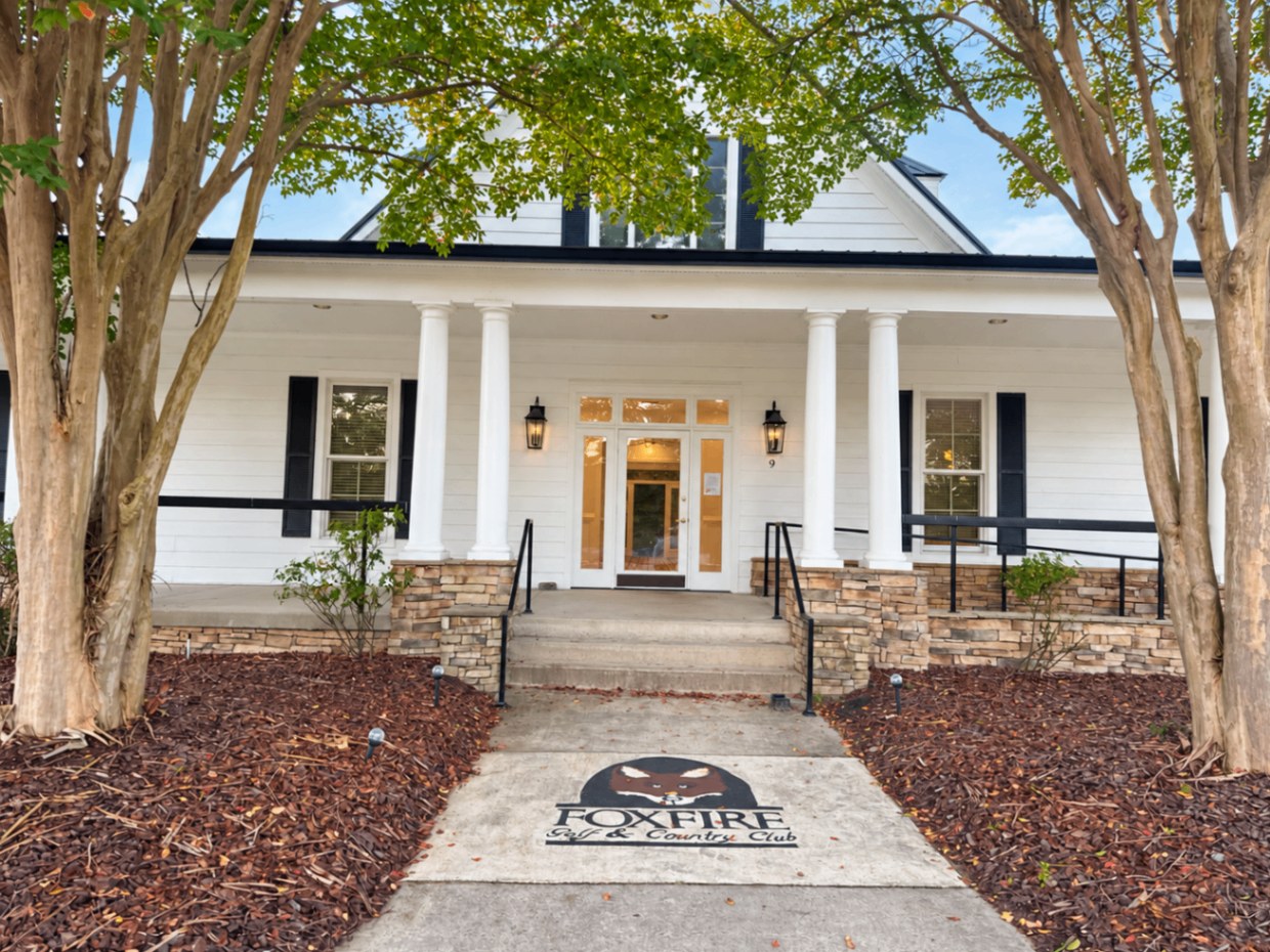 Columned front porch of the Foxfire Golf & Country Club with fox emblem on the walkway