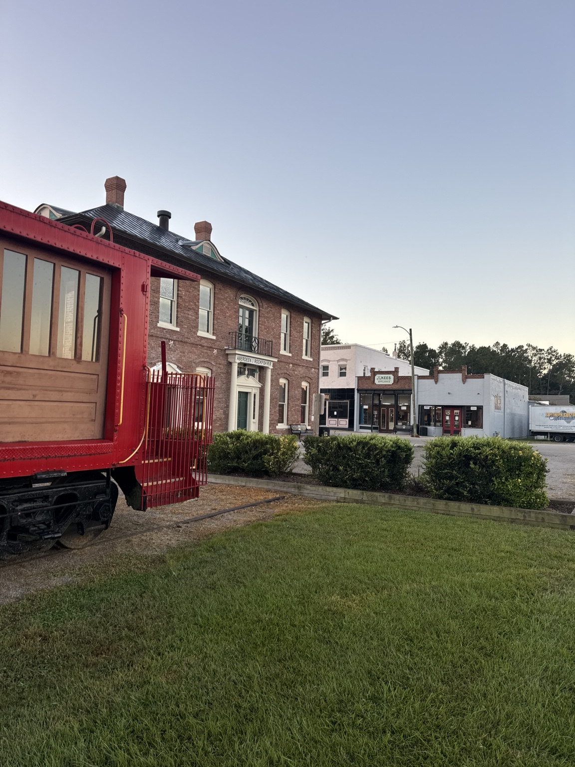 Red caboose beside the historic brick depot buildings in Aberdeen