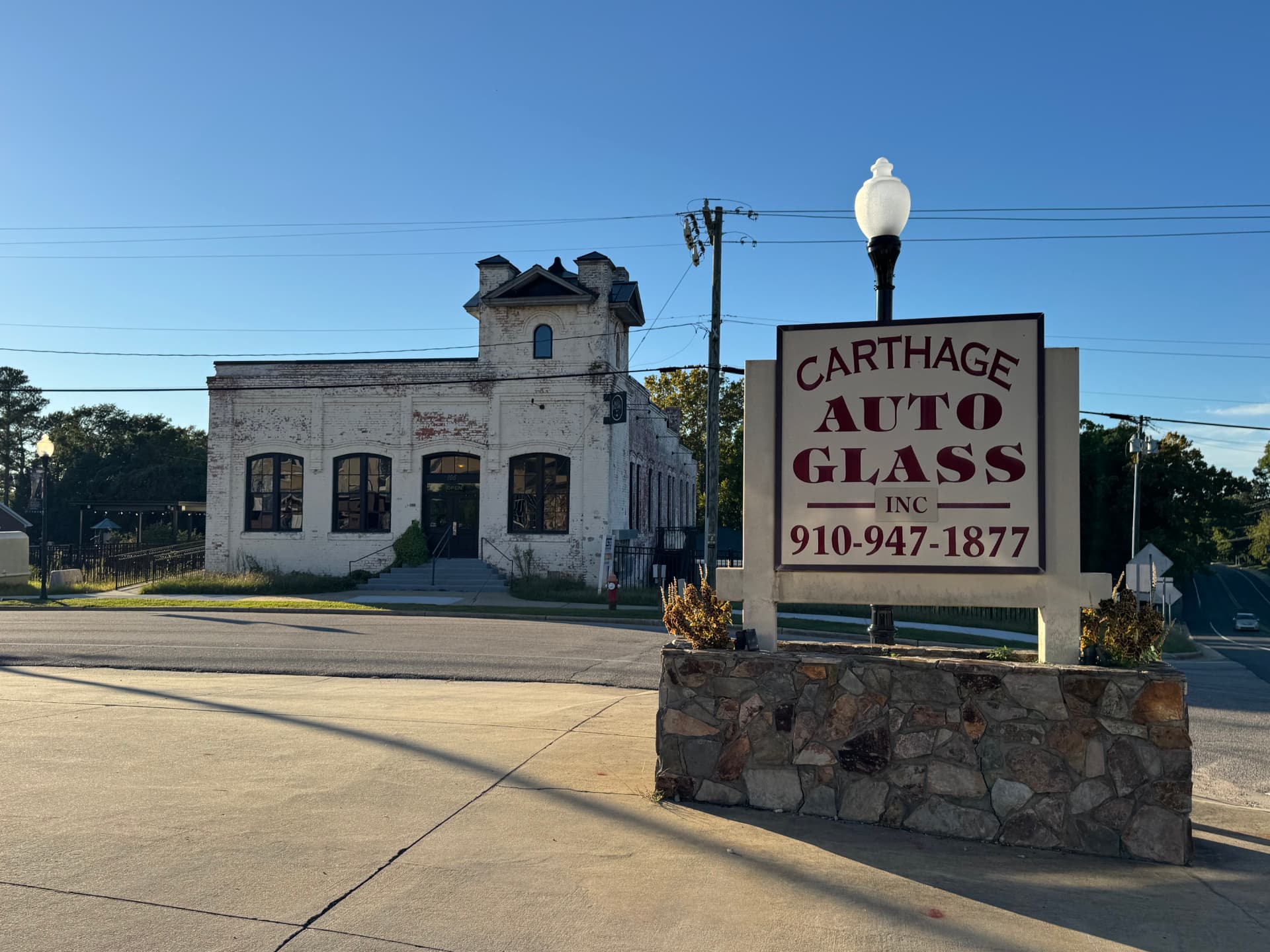 Carthage Auto Glass sign and historic white brick building in downtown Carthage